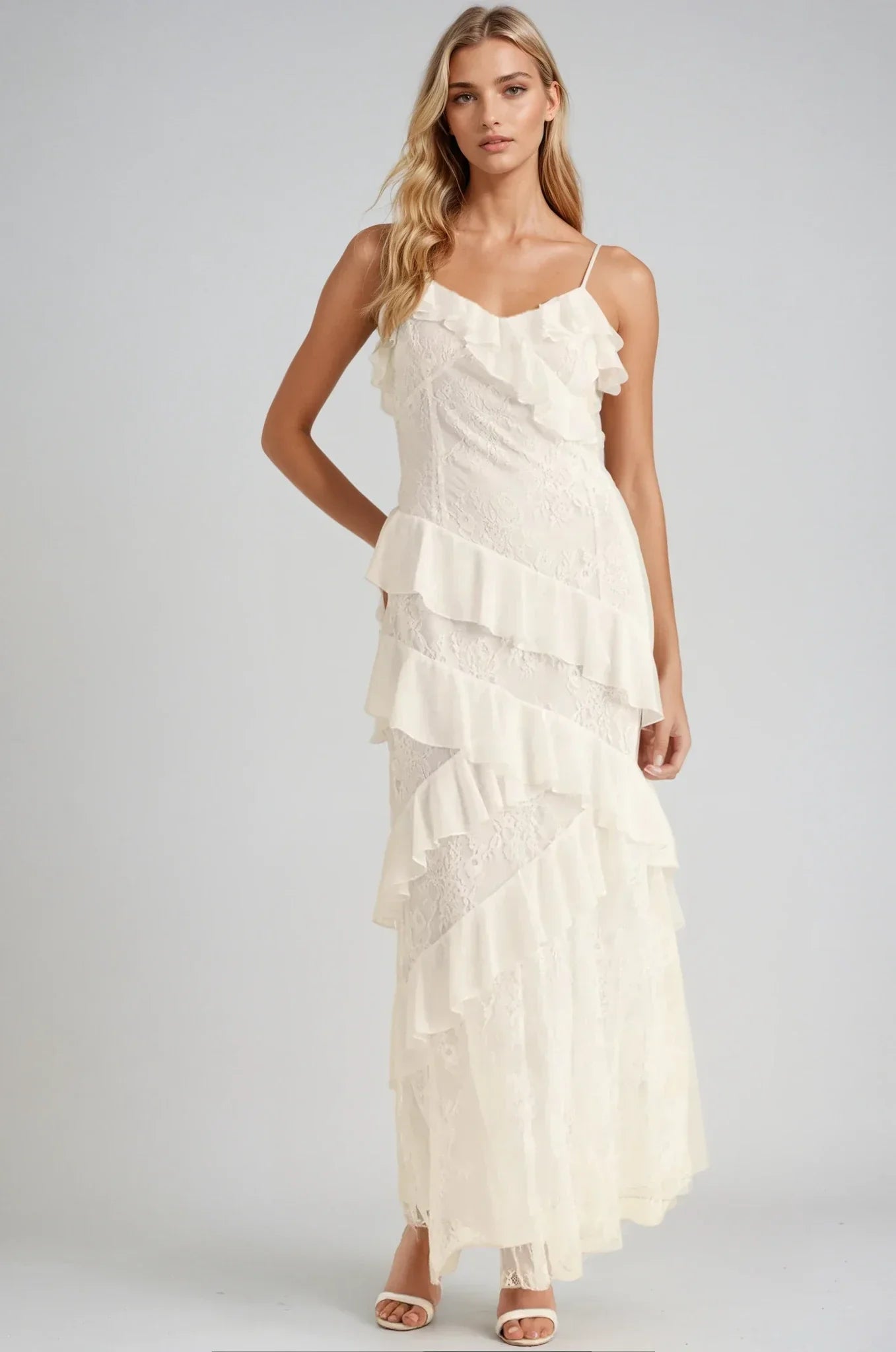 Elegant off-white maxi Celeste Dress with cascading ruffles and lace inserts, perfect for weddings and formal occasions.