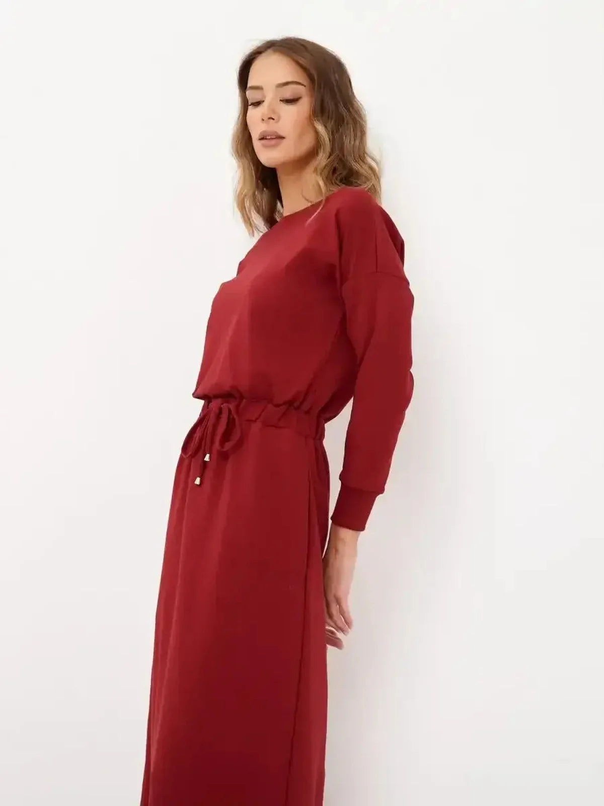 Model wearing a red maxi dress with long sleeves and a drawstring waist, showcasing elegant style for women.