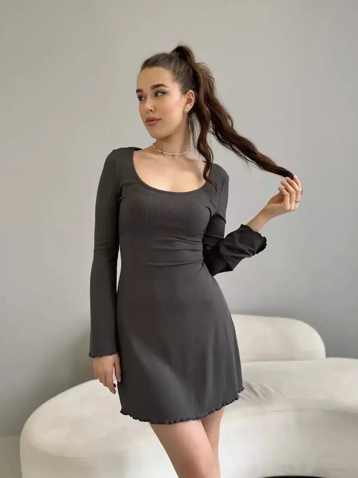 Model wearing the Shadow Flare mini dress in grey, showcasing a square neckline and bell sleeves, perfect for casual or formal occasions.