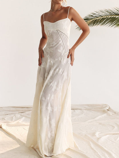 Elegant white maxi dress with delicate lace detailing and spaghetti straps, perfect for summer weddings and special occasions.