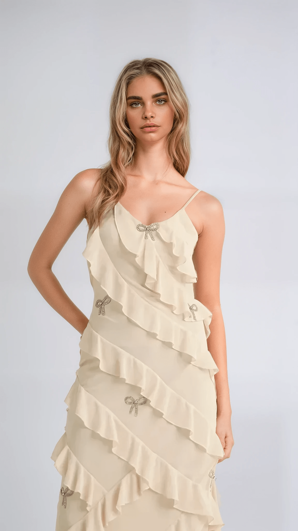 Elodie Dress: Ethereal maxi dress in creamy champagne with ruffles and crystal bow embellishments, perfect for weddings and special occasions.