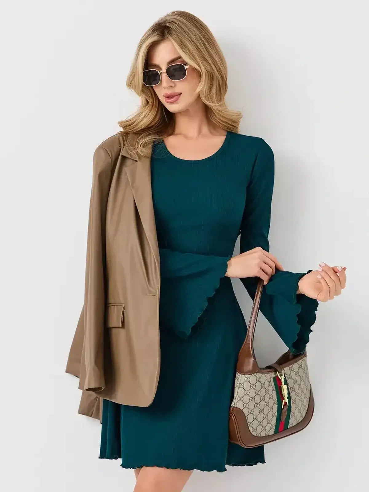 Model wearing the Emerald Whisper mini dress by Lauven, styled with a blazer and handbag.