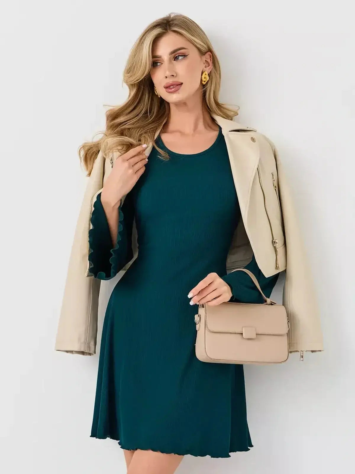Emerald Whisper mini dress by Lauven, styled with a beige jacket and handbag, showcasing a chic day-to-night look.