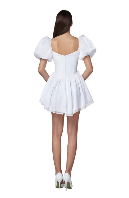 Back view of the Faye Mini Dress featuring puff sleeves, a square neck, and a flared white skirt, perfect for summer occasions.