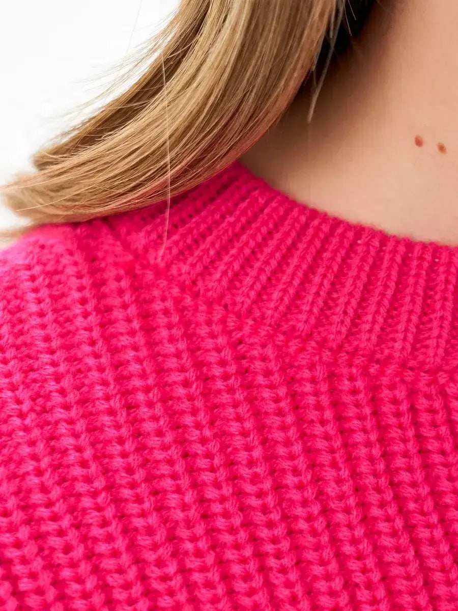 Close-up of the textured knit of the Lauven Flamingo Sweater in bold fuchsia, showcasing its vibrant color and cozy fabric.