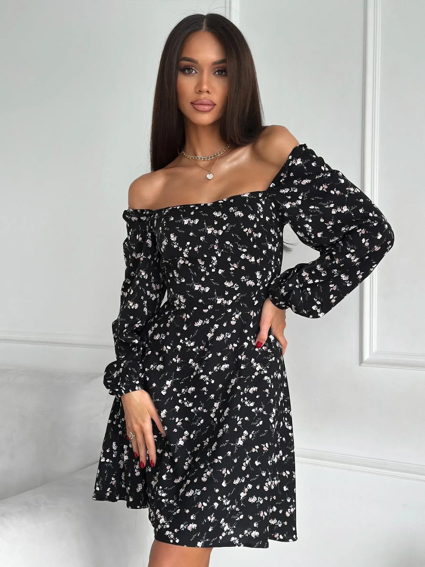 Charming black mini dress with floral print, off-shoulder design, and long sleeves, perfect for parties and casual outings.