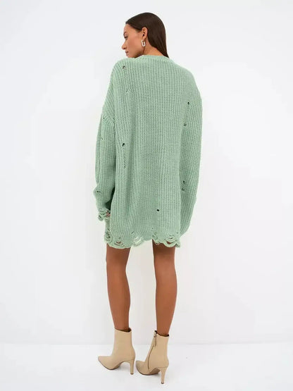 Model wearing a mint green chunky knit mini dress with distressed details, showcasing a casual and edgy style.