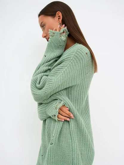 Model wearing a soft mint green Frost Knit Mini sweater dress with distressed accents, showcasing oversized fit and chunky knit texture.