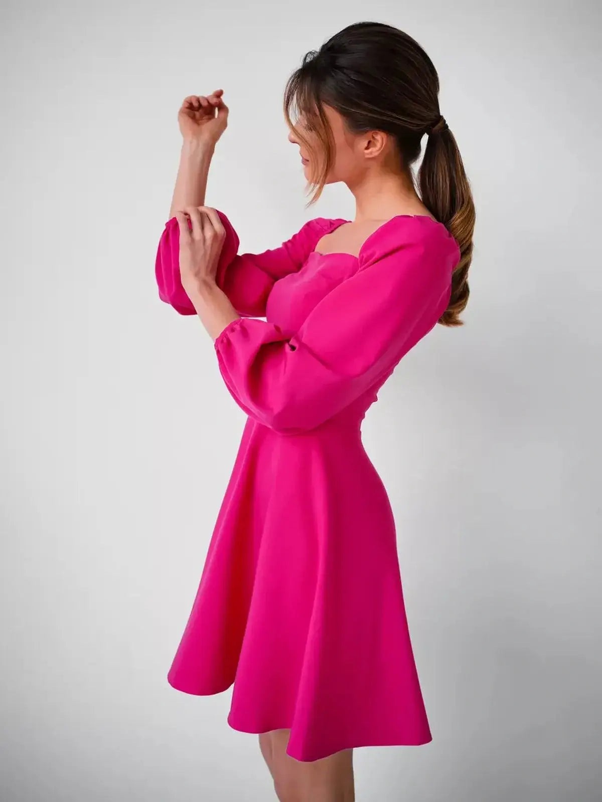 Fuchsia mini dress with structured square neckline and puff sleeves, perfect for summer wedding or party.