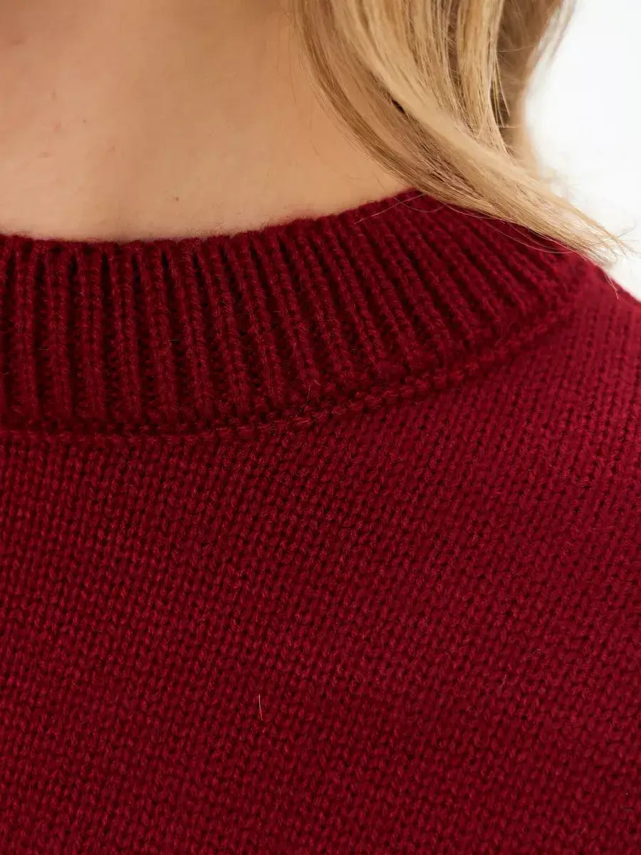 Close-up of the collar on a garnet sweater by Lauven, showcasing the rich deep burgundy knit texture.