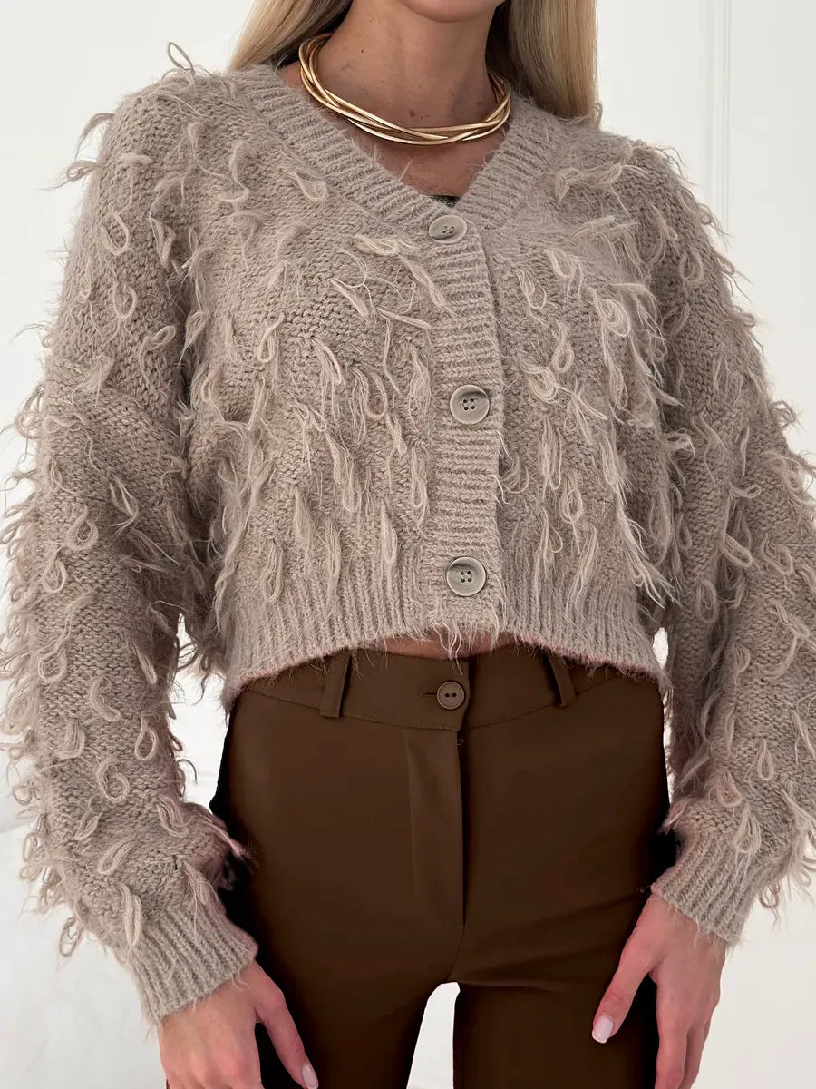 Sahara Cardigan by Lauven, cropped oversized beige bouclé knit with feathered fringe and V-neckline.