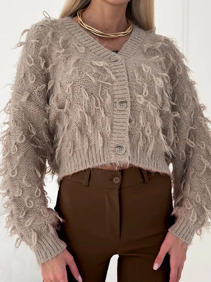 Sahara Cardigan by Lauven, cropped oversized beige bouclé knit with feathered fringe and V-neckline.