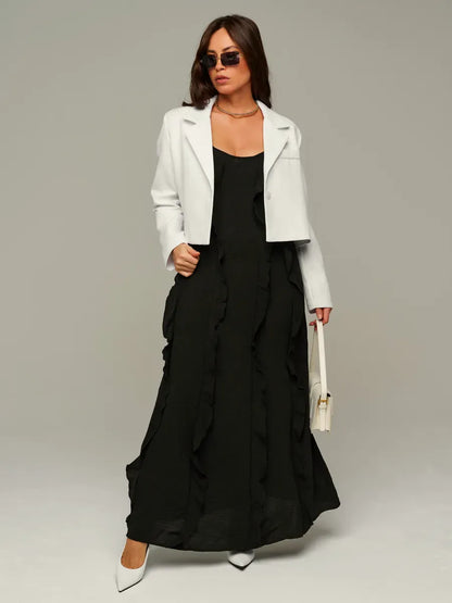 Model wearing Luna Blazer, a cropped ivory women’s jacket, over a black dress for a chic look.