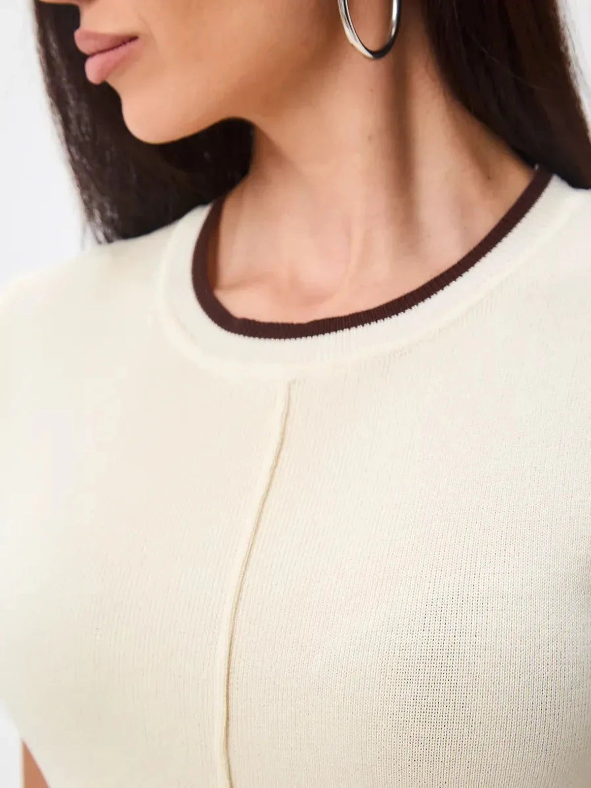 Close-up of the neckline of the Marbella Mini Dress by Lauven, showcasing its soft knit and contrast trim.