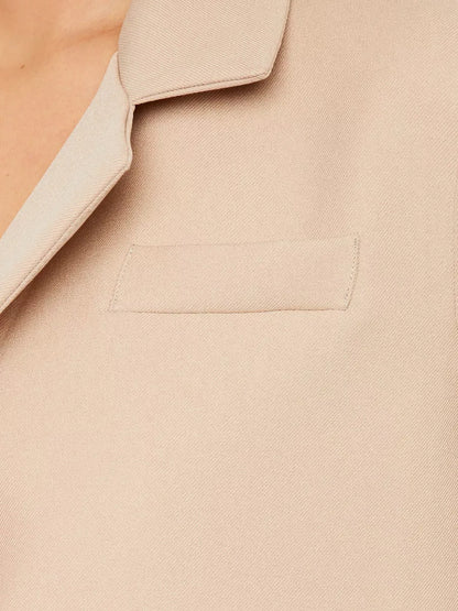 Sahara Blazer by Lauven — Close-up of the women's beige cropped oversized jacket fabric and pocket detail.