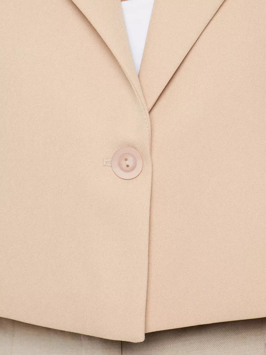 Close-up of the Sahara Blazer by Lauven, showcasing the button detail on a beige cropped oversized jacket.