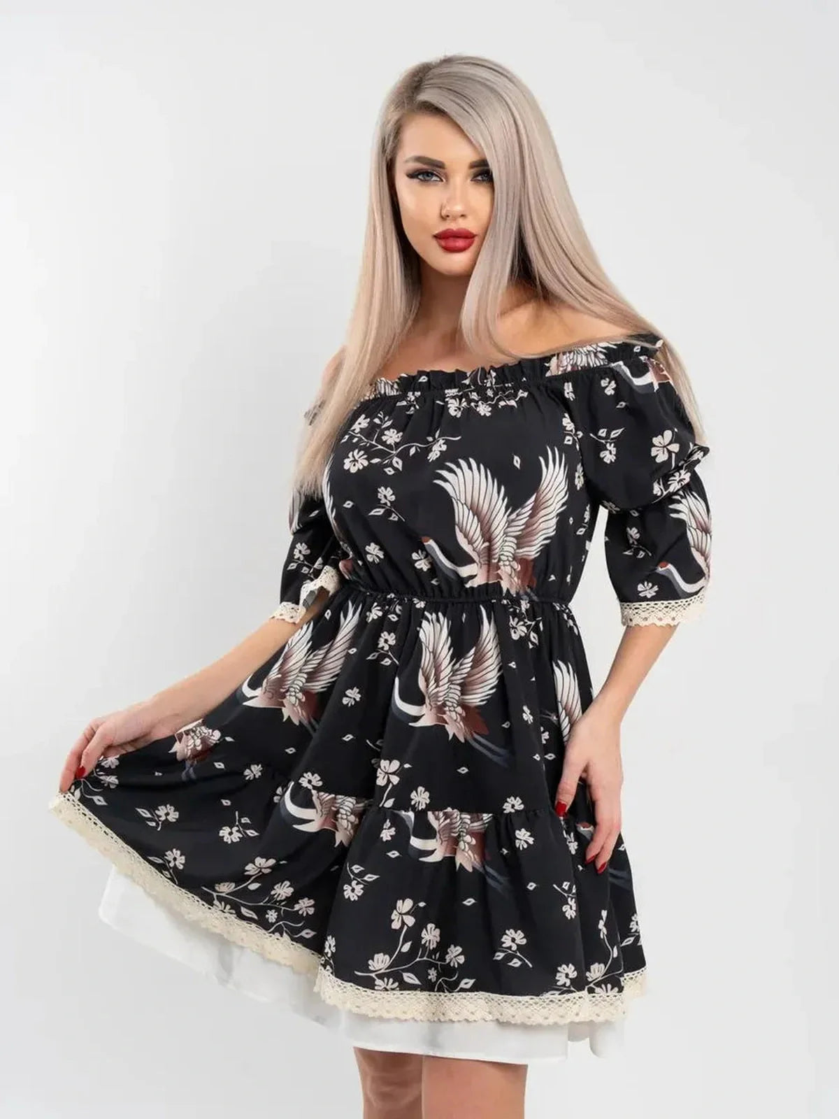 Off-shoulder black Crane Bloom mini dress with floral print and A-line silhouette, featuring a cinched waist and delicate lace trim.