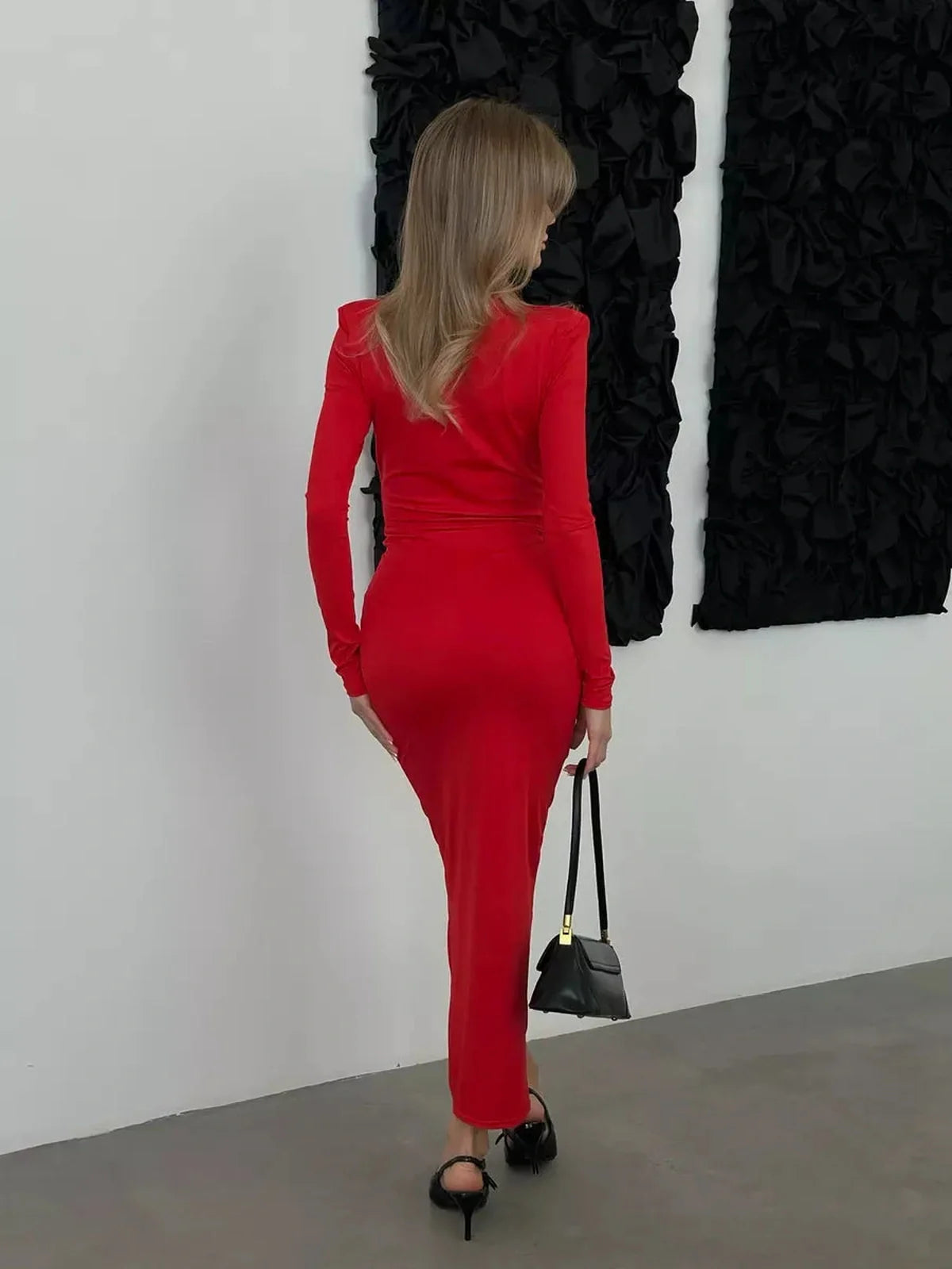 Model wearing a Sculpted Glam Maxi Dress in red, showcasing a sleek fit and long sleeves, perfect for elegant occasions.