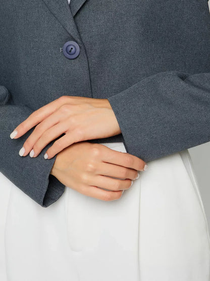 Athena Blazer by Lauven showcasing women's grey cropped oversized jacket detail with stylish button and elegant sleeves.
