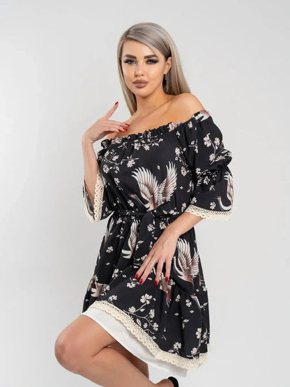 Model wearing the Crane Bloom off-shoulder mini dress with crane and floral print, showcasing its elegant A-line silhouette.