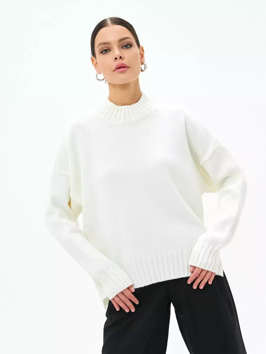 A woman modeling the Astra Sweater by Lauven, an oversized wool blend knit in elegant cream white.