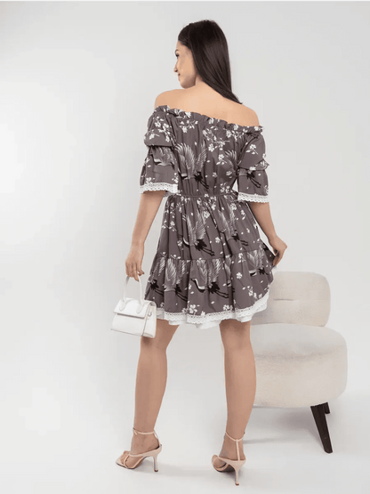 Back view of a woman in a grey-brown off-shoulder mini dress with cranes and cherry blossoms.