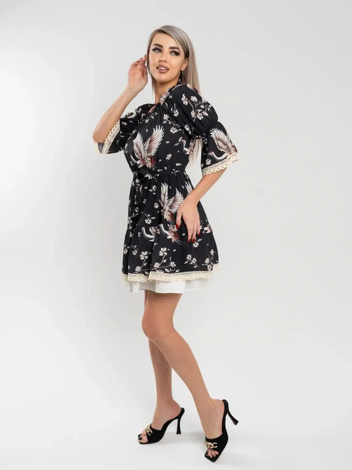 Crane Bloom mini dress featuring an off-shoulder design, A-line silhouette, and crane floral print on a black background.
