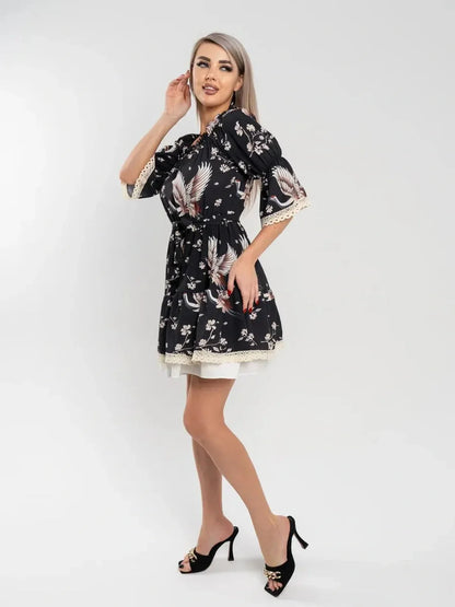 Crane Bloom mini dress featuring an off-shoulder design, A-line silhouette, and crane floral print on a black background.