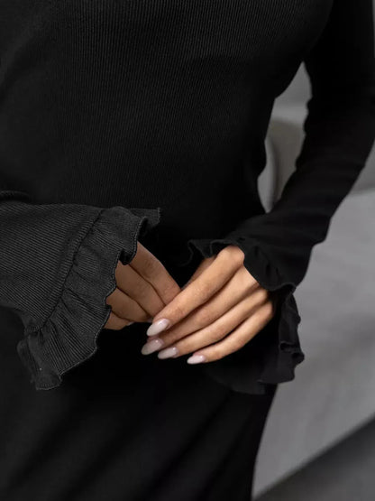 Close-up of hands showcasing the ruffled sleeves of the Noir Flare black mini dress, highlighting its elegant design.