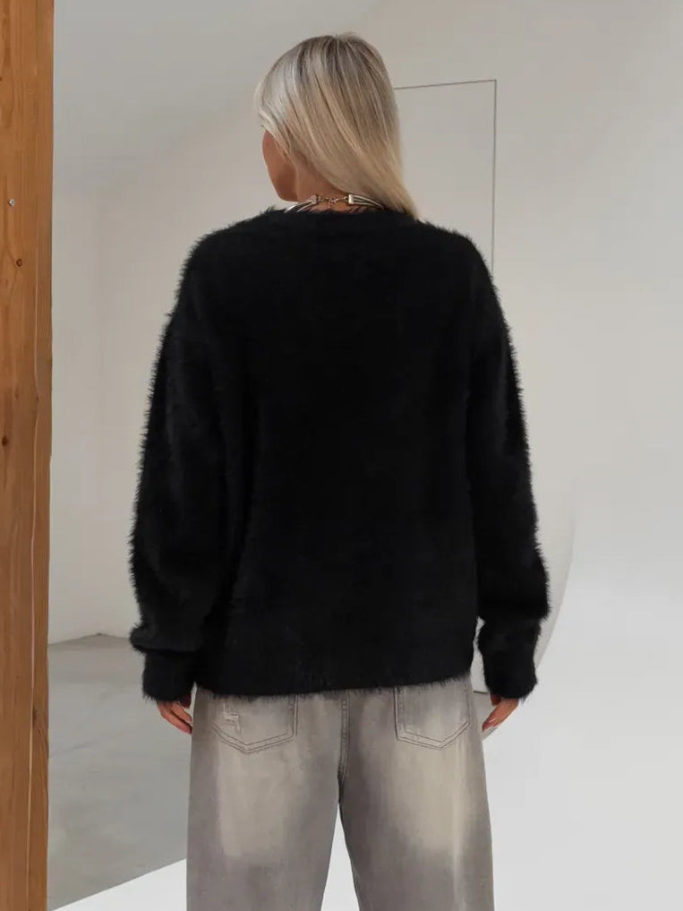 Nyx Cardigan from Lauven, oversized black fluffy knit, back view showcasing relaxed silhouette and warm texture.
