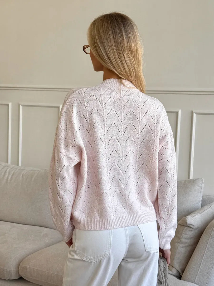 Back view of a woman wearing a soft pink Blush Cardigan with intricate openwork lace pattern by Lauven.