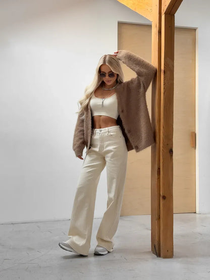 Model wearing a stylish Marlo Cardigan by Lauven, in oversized brown fluffy knit with button closure, paired with wide-leg pants.