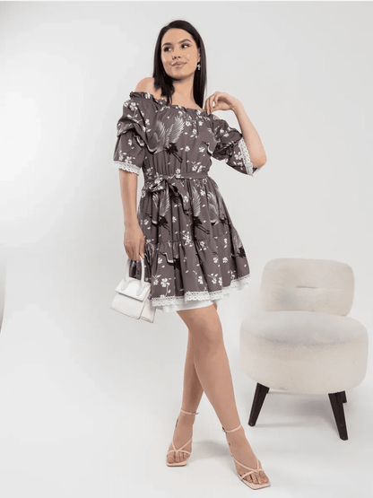 Woman in a grey-brown off-shoulder dress with cherry blossoms and cranes, showcasing grace and femininity.