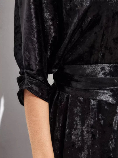 Detail of the Aveline Maxi Dress by Lauven, showcasing rich black velvet fabric and rolled three-quarter sleeves.