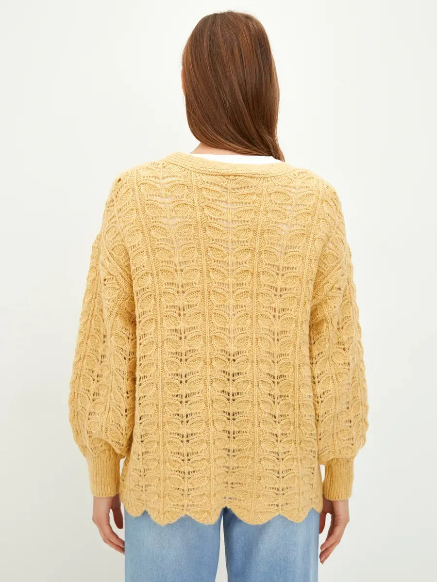 Back view of Solenne Cardigan by Lauven in warm yellow with textured knit pattern, perfect for effortless layering.