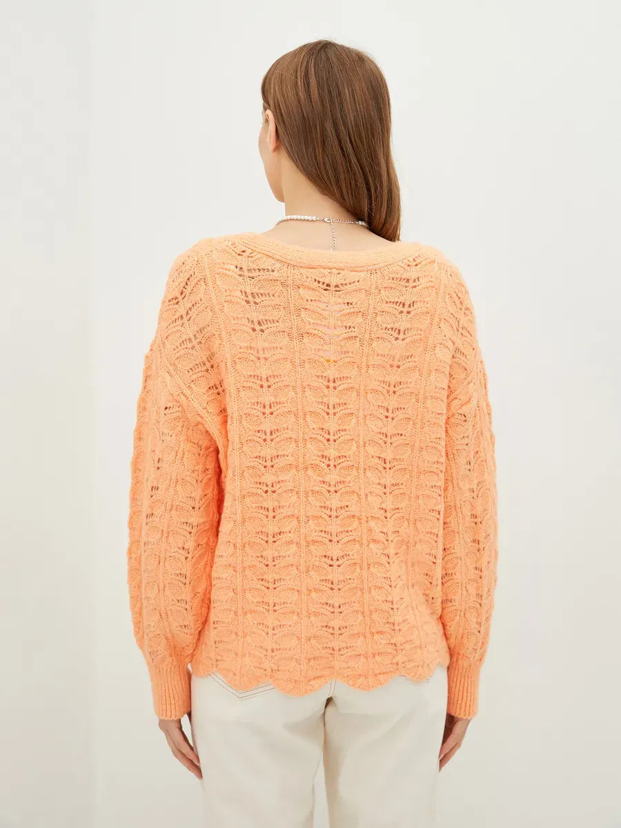 Elysia Cardigan by Lauven in coral, showcasing soft jacquard knit from the back, perfect for stylish comfort.
