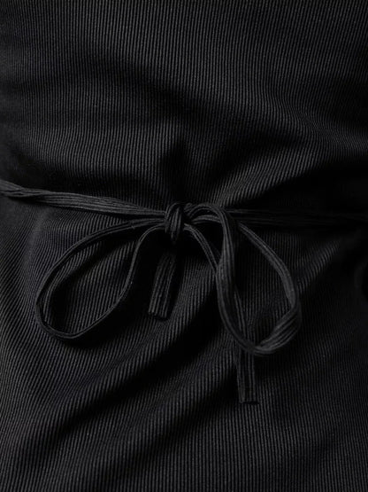 Close-up of lace-up back detail of Noir Flare mini dress, showcasing black ribbed fabric and stylish bow.