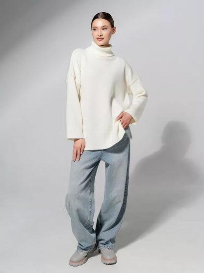 Woman wearing Luna Sweater by Lauven, oversized knit in soft milk white, paired with relaxed-fit jeans.