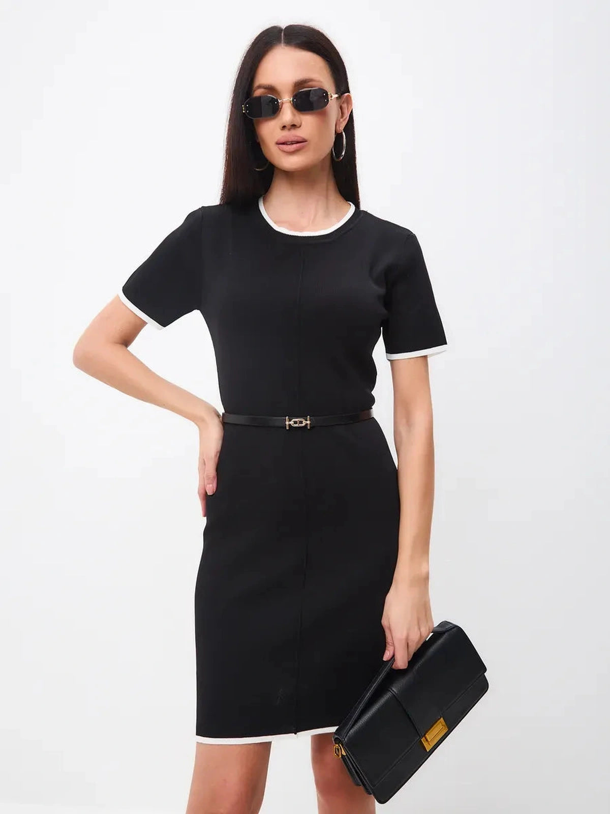 Stylish woman wearing Solara Mini Dress with contrast trim, sunglasses, and clutch bag by Lauven.