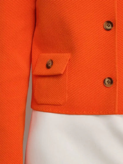 Close-up of the Coral Jacket by Lauven, featuring a cropped design and button closure in bold orange fabric.