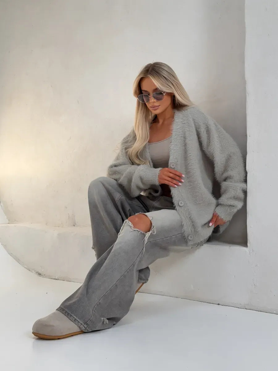 Model wearing Eira Cardigan by Lauven, an oversized light gray fluffy knit, paired with casual gray pants and accessories.