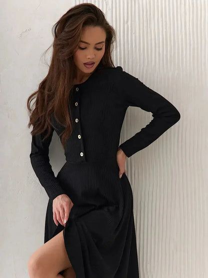 Model wearing the Serene Grace Midi Dress, showcasing its black ribbed texture and decorative buttons.