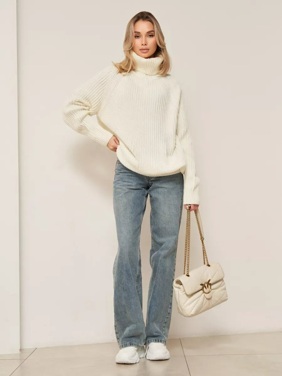 Luna Sweater by Lauven, oversized white knitwear with turtleneck style, paired with jeans and a stylish handbag.