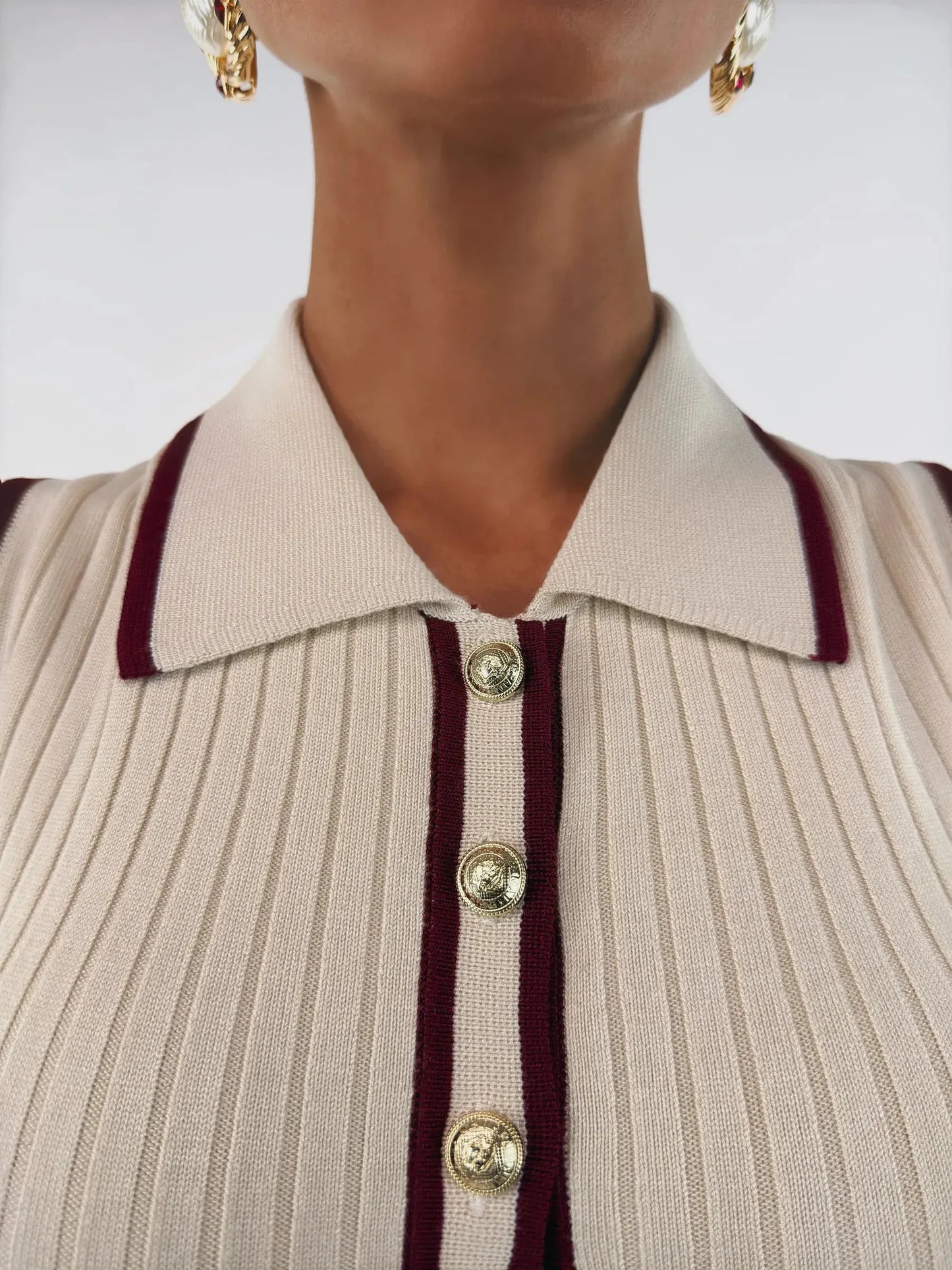 Close-up of Serena Midi Dress collar showing cream ribbed knit fabric and burgundy trim with gold-tone buttons.