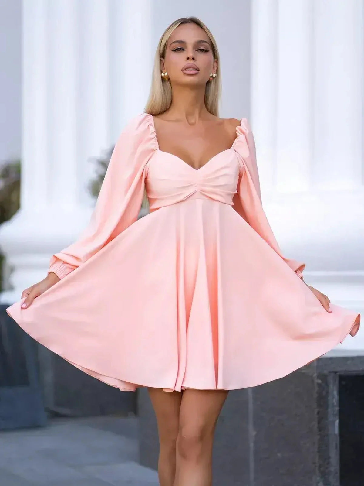 Peach Bloom mini dress featuring a romantic V-neckline and voluminous long sleeves in soft peach-pink hue.