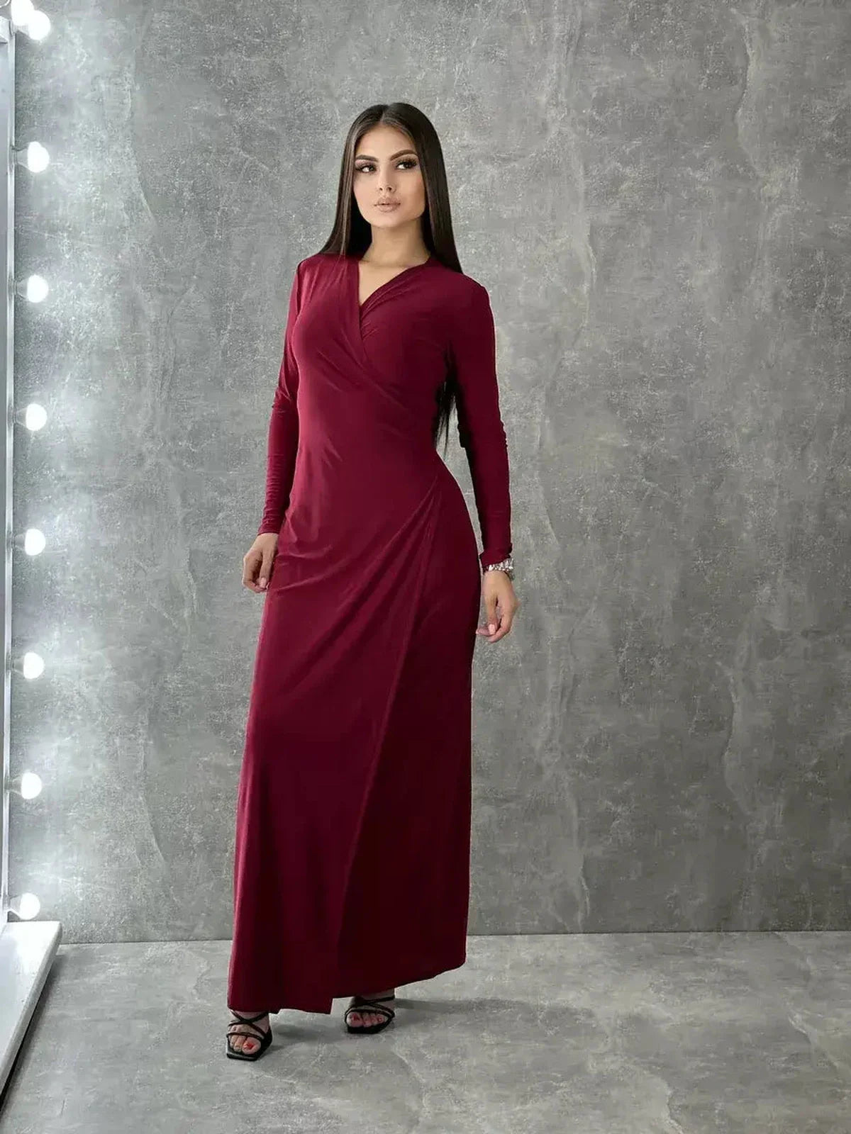 Model showcasing the Crimson Grace Maxi Dress in elegant burgundy with a V-neck and wrap silhouette.