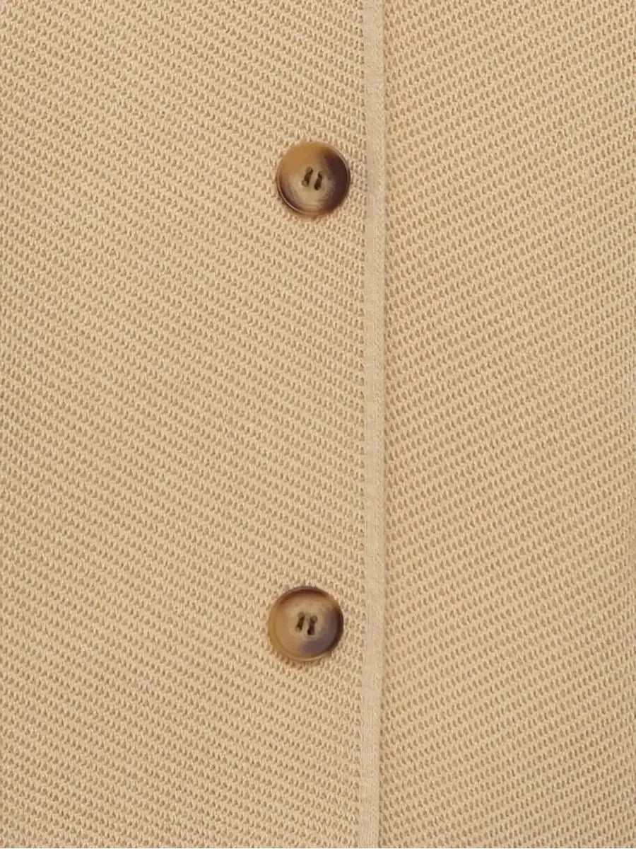 Close-up of the button detail on the cropped light beige Alba Jacket by Lauven.