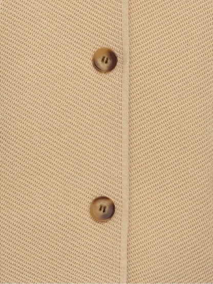 Close-up of the button detail on the cropped light beige Alba Jacket by Lauven.