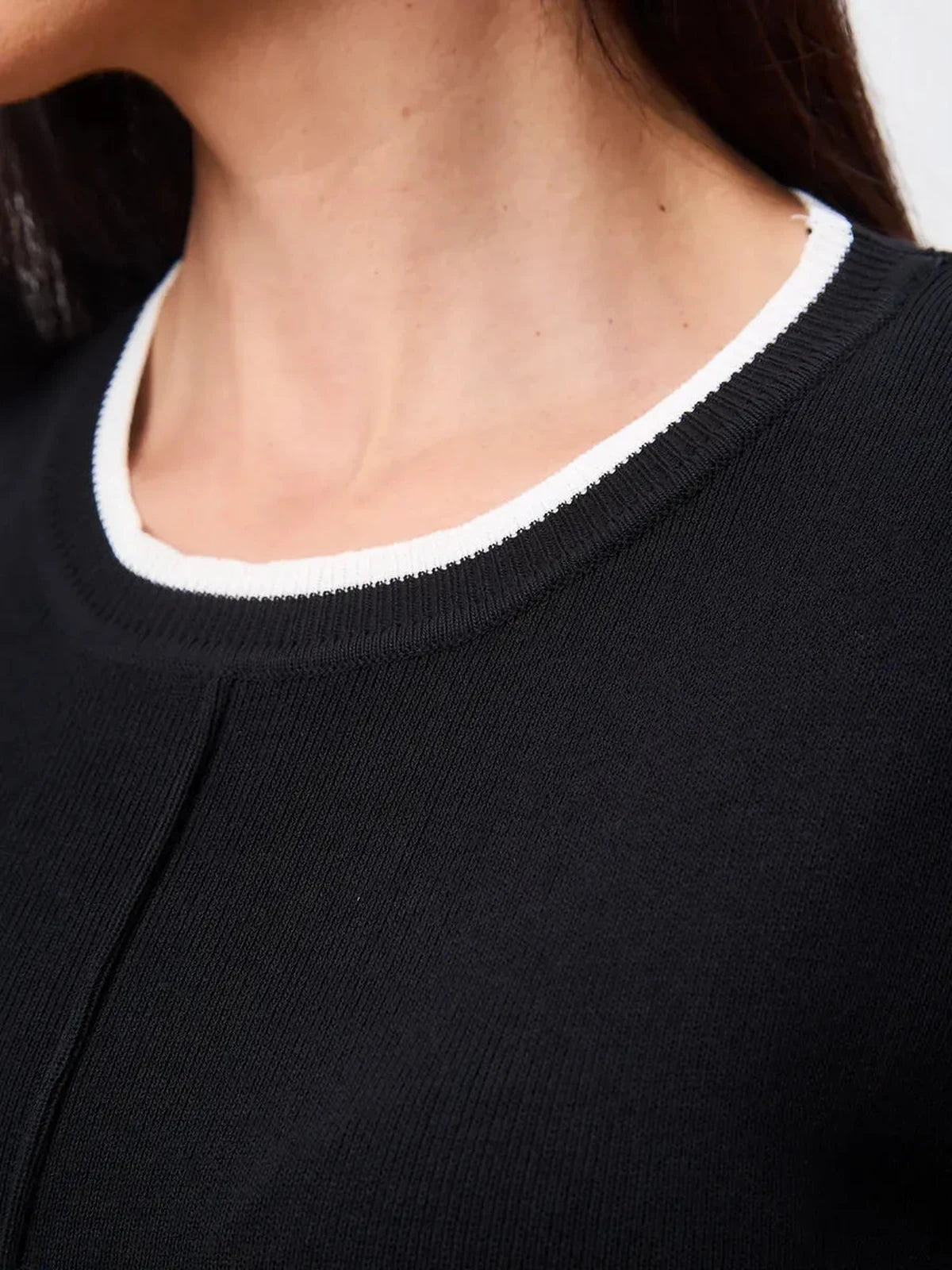 Close-up of the Solara Mini Dress neckline featuring sleek contrast trim by Lauven.