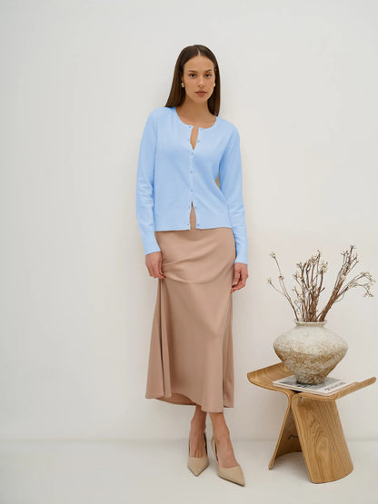 Celeste Cardigan by Lauven, lightweight blue knitwear with button closure, styled with a beige skirt.